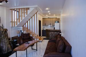 a living room with a couch and a table and a kitchen at Villa Harmony in Chakvi