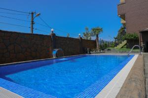 a swimming pool next to a fence with a blue at Villa Harmony in Chakvi