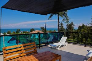 a patio with a bench and a view of the ocean at Villa Harmony in Chakvi