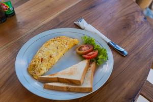 a plate of food with an omelet and toast at Tregge Surf Camp Uluwatu in Uluwatu