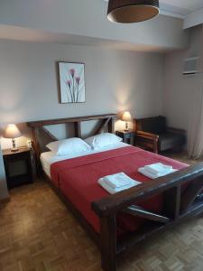 a bedroom with a large bed with a red blanket at Spyros Studio in Paleo Tsifliki