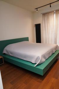 a bed in a room with a green bed frame at Krtsanisi Grande apartment in Tbilisi City