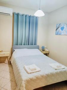 a bedroom with a bed with two towels on it at Ioanna's sweet & cozy apartment with garden view in Monemvasia +8 photos