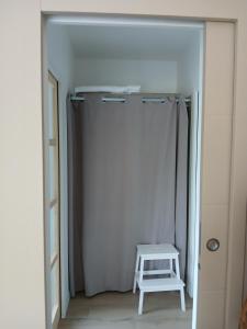 a white closet with a stool in a room at Chambre avec terrasse et salle de bain privative in Saint-Thurial