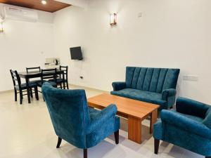 a waiting room with blue chairs and a table at Gamodh Citadel Resort in Anuradhapura