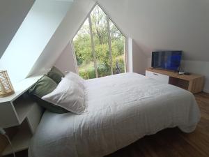 a bedroom with a large bed and a window at le petit moulin de Kerloroc in Ploudalmézeau