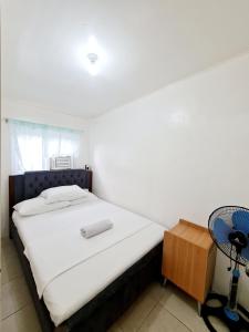 a bedroom with a bed and a fan at Calapan City Cheapest House Transient Guest Rental L39 in Calapan