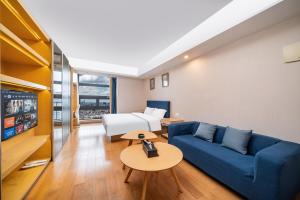 un soggiorno con un divano blu e una TV di 寓米公寓(琶洲会展中心广州塔店) a Canton