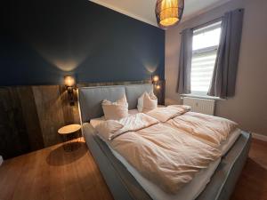 a bedroom with a bed with white sheets and a window at VILLA am Paulsberg mit Sauna - V4 in Braunlage