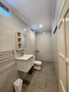 une salle de bain blanche avec toilettes et lavabo dans l'établissement Capricorn Villa, à Seminyak