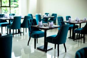 a dining room with tables and chairs with food on them at SpringWells Hotel ltd in Maua +59 photos