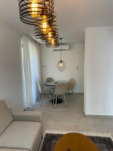 a living room with a table and a chandelier at Apartmani Bare in Jajce +8 photos