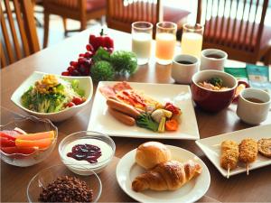 a wooden table with plates of food on it at Osaka Joytel Hotel in Osaka