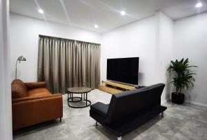 a living room with a couch and a tv and a chair at Ryde guest house in Sydney