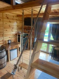 a room in a log cabin with a swing at Domek w polu Sulów in Sułów