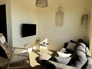 a living room with a couch and a tv at Palm View Residence with Private Rooftop in Larnaka