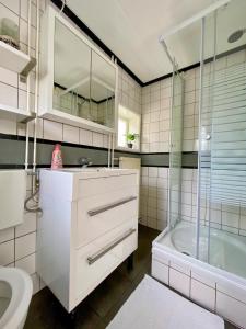 a bathroom with a sink and a shower and a tub at La Mare in Zoutelande