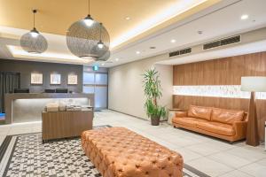 an office lobby with a couch and a desk at Meitetsu Inn Nagoya Kanayama Annex in Nagoya