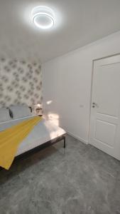 a bedroom with a bed and a white wall at Vegas luxury apartment in Constanţa