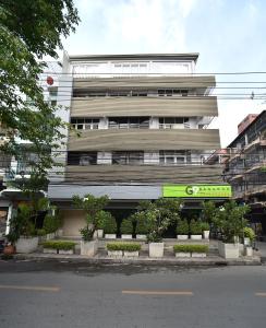 een hoog wit gebouw met planten ervoor bij G9bangkok in Bangkok