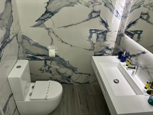 a bathroom with a white toilet and a sink at Playa Home Isla in Isla +9 photos