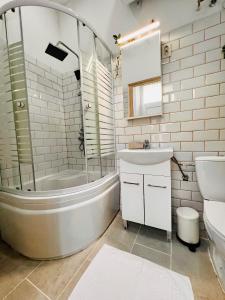 a bathroom with a tub sink and a toilet at Quiet Luxury Apartment with 2 rooms in the City Centre BB in Budapest