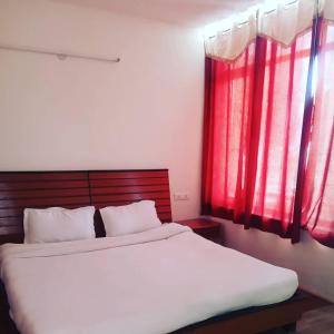 a bedroom with a large bed with red windows at Moon Palace Homestay Ladakh by LexStays in Leh +6 photos