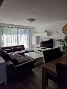 una sala de estar con un sofá y una mesa en Maison a 10 min de la plage, en Ploemeur