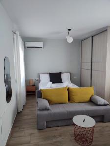 a living room with a couch with yellow pillows at Little Dream House in Valanidorachi