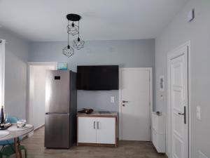 a kitchen with a stainless steel refrigerator and a table at Little Dream House in Valanidorachi