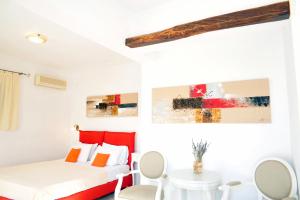 Habitación blanca con cama, mesa y sillas en Medusa Beach Resort & Suites, en Plaka