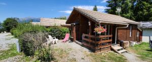 a small cabin with a pink chair in front of it at Chalet calme in Saint-Léger-les-Mélèzes