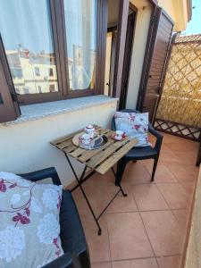 einen Tisch und zwei Stühle auf einem Balkon mit einem Tisch und einem Tisch in der Unterkunft Mare e Monti - Bilocale indipendente in Tortolì