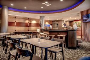 a restaurant with tables and chairs and a bar at SpringHill Suites Savannah Airport in Savannah