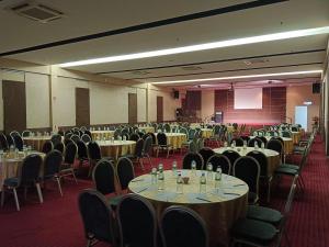 a banquet hall with tables and chairs and a screen at Fuller Hotel in Alor Setar