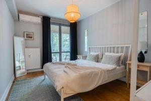 ein Schlafzimmer mit einem Bett und einem großen Fenster in der Unterkunft Boutique Luxury Apartment - Alhambra in Bukarest
