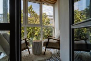 Zimmer mit einem Fenster mit einem Stuhl und einem Tisch in der Unterkunft Boutique Luxury Apartment - Alhambra in Bukarest