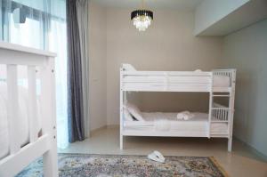 Diamond 2BR Luxurious Retreat in Al Reem في أبوظبي: سرير أبيض بطابقين في غرفة مع ثريا +20 صورة