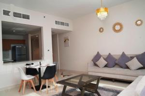 Diamond 2BR Luxurious Retreat in Al Reem في أبوظبي: غرفة معيشة بها أريكة وطاولة