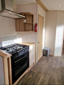 a kitchen with a stove top oven in a room at Summer Breeze Getaway, West Sands in Selsey