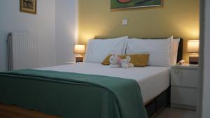 a white bed with a stuffed animal sitting on it at Electra in Saronida