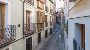 an alley in an old town with wooden windows at El Capricho de Toledo in Toledo