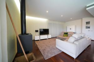 un soggiorno con un divano bianco e una televisione di House on the Top Guimarães a Guimarães