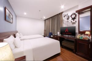 a hotel room with a white bed and a television at A25 Hotel - 63A Phương Liệt in Hanoi