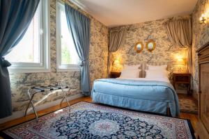 a bedroom with a blue bed and a rug at Le Moulin de Francueil in Francueil +49 photos
