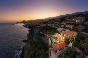 an aerial view of a town on a cliff near the ocean at Islander - Funchal Seaside Villas in Funchal
