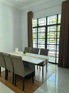 a dining room with a large table and chairs at Senjaloka Homestay SWIMMING POOL in Bachok +3 photos