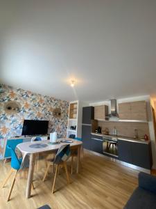 a kitchen and living room with a table and chairs at Welc'Home in Saint-Valéry-en-Caux