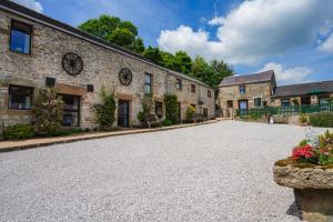 an empty driveway in front of a brick building at Bolehill Farm Cottages in Bakewell