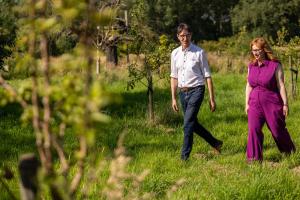 a man and a woman walking through the grass at DeStoker in Hasselt